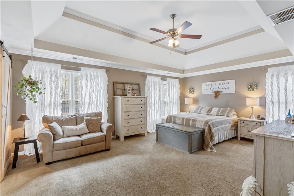 860 Valley Drive Canton, GA 30114 - Photo 22 of 62 a spacious bedroom with a bed and a chandelier
