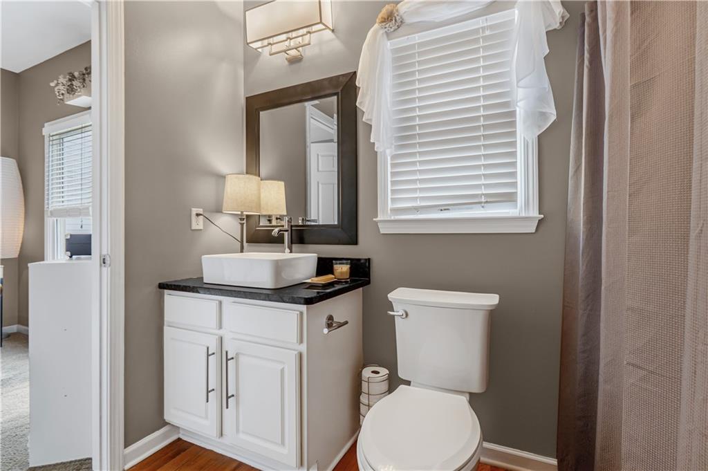 860 Valley Drive Canton, GA 30114 - Photo 29 of 62 a bathroom with a toilet a sink a mirror and a window