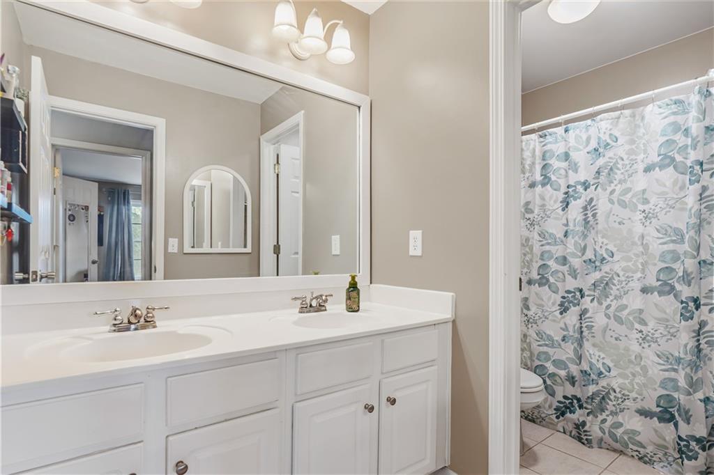 860 Valley Drive Canton, GA 30114 - Photo 32 of 62 a bathroom with a sink a mirror a vanity and a shower
