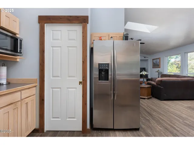 a kitchen with cabinets wooden floor and a window