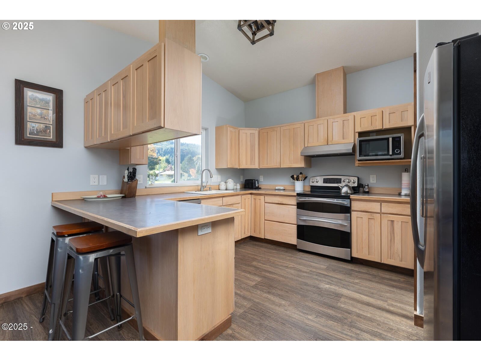 25855 Chinook Street Cloverdale, OR 97112 - Photo 10 of 26 a kitchen with stainless steel appliances a sink a stove a refrigerator cabinets and a window