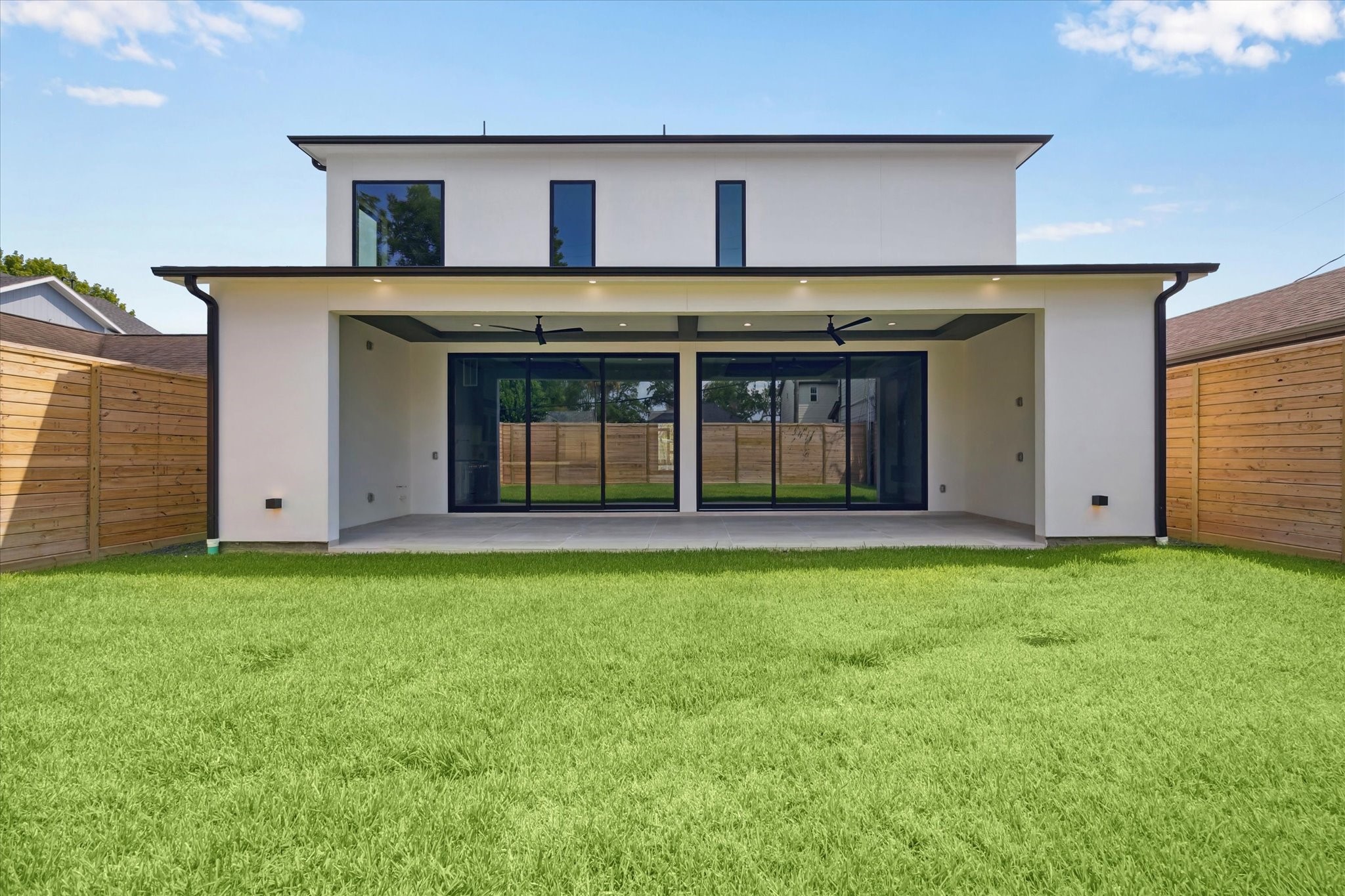 2120 Branard Street Houston, TX 77098 - Photo 32 of 33 The back view of the home is both striking and inviting, showcasing clean modern architecture framed by sleek lines and expansive glass doors that blend indoor and outdoor living.