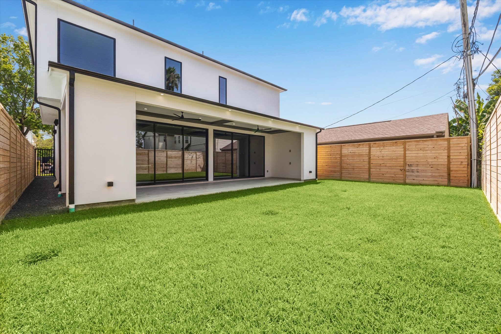 2120 Branard Street Houston, TX 77098 - Photo 33 of 33 Surrounded by contemporary wood fencing for privacy, the lush green lawn provides ample space for recreation or future customization, whether for a pool, garden, or play area. This thoughtfully designed outdoor retreat balances style, comfort, and functionality, making it the perfect setting for gatherings or peaceful relaxation at home.