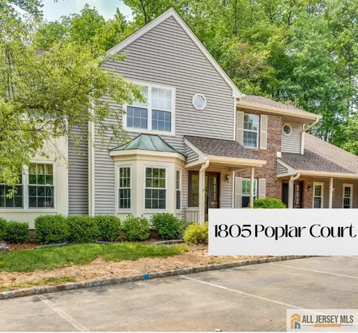 a view of a white house with large windows next to a road
