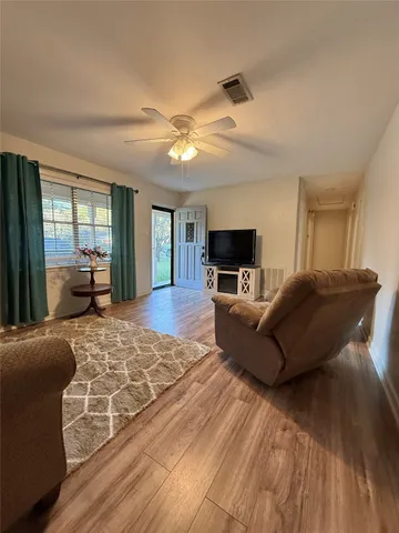 a living room with furniture and a wooden floor