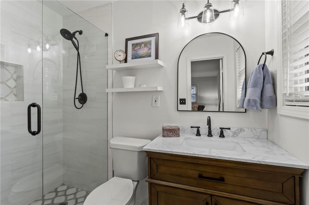 4061 North Cooper Lake Road Southeast Smyrna, GA 30082 - Photo 20 of 45 a bathroom with a granite countertop sink a toilet and shower