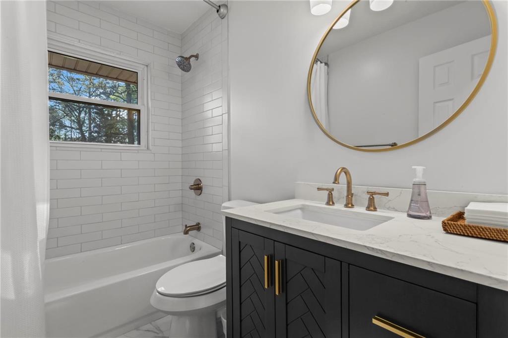 4061 North Cooper Lake Road Southeast Smyrna, GA 30082 - Photo 24 of 45 a bathroom with a toilet a sink a mirror and a bathtub