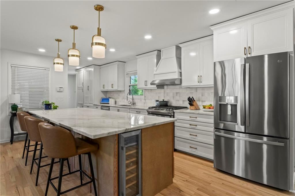 4061 North Cooper Lake Road Southeast Smyrna, GA 30082 - Photo 7 of 45 a kitchen with kitchen island granite countertop a refrigerator a sink dishwasher a stove and white cabinets with wooden floor