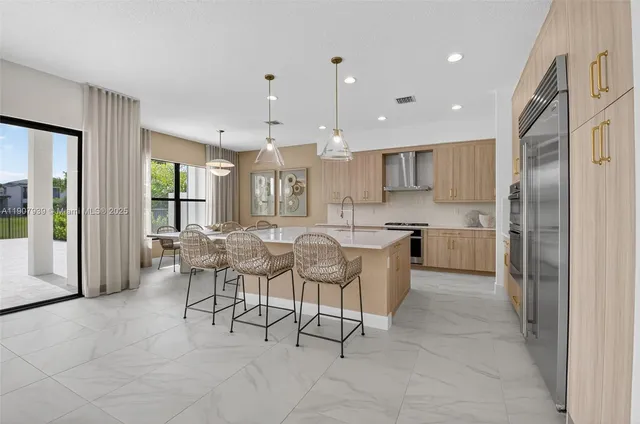 a kitchen with stainless steel appliances granite countertop a sink refrigerator and cabinets