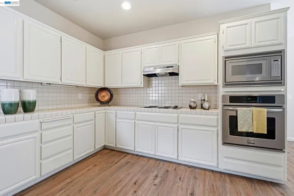 a kitchen with white cabinets stainless steel appliances and sink