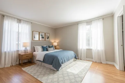 a bedroom with a bed and a large window