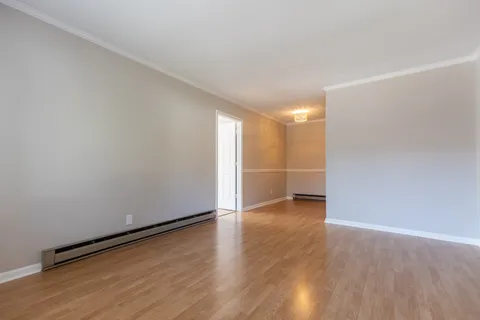 a view of an empty room with wooden floor