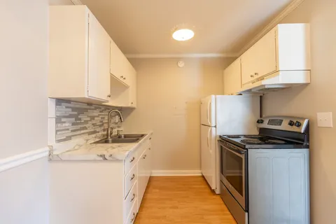 a kitchen with stainless steel appliances a stove a sink and a refrigerator
