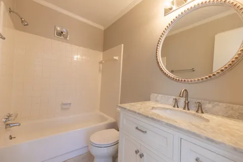 a bathroom with a granite countertop sink a toilet and bathtub
