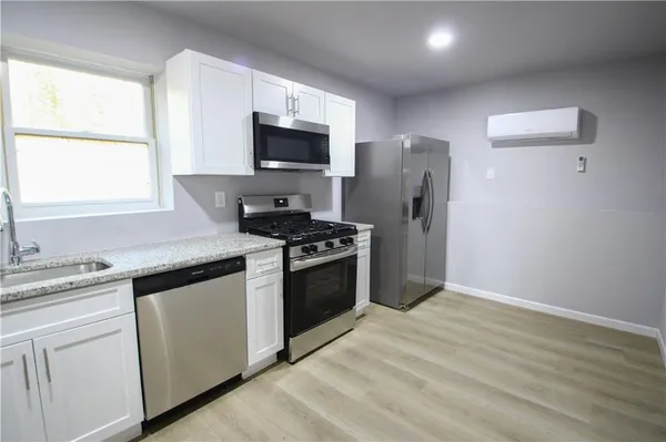 a kitchen with stainless steel appliances a stove microwave and refrigerator