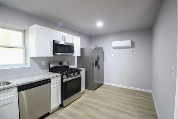 a kitchen with stainless steel appliances a stove microwave and refrigerator