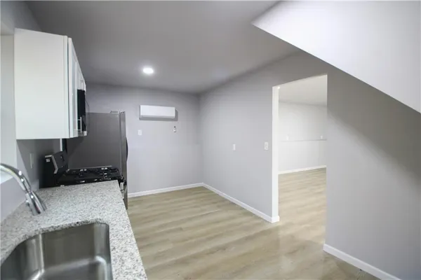 a kitchen with granite countertop a refrigerator and a sink