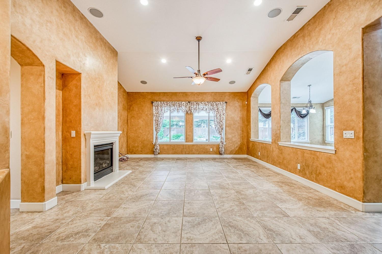 2267 Graybark Avenue Clovis, CA 93619 - Photo 13 of 42 a view of an empty room with a fireplace and a window