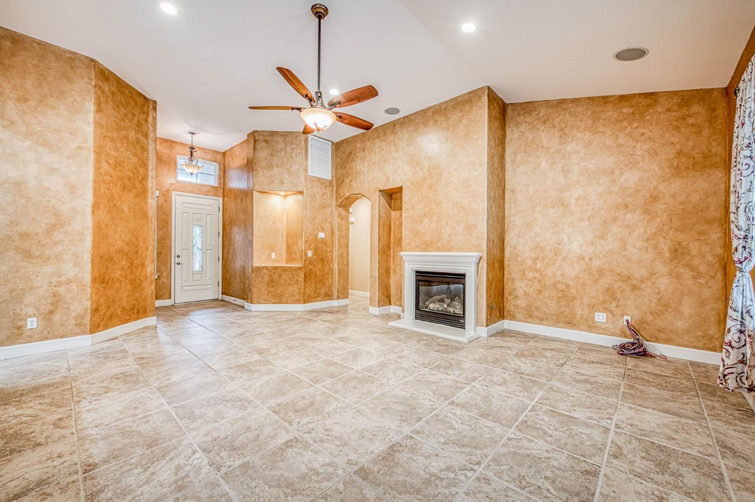 2267 Graybark Avenue Clovis, CA 93619 - Photo 14 of 42 a view of an empty room with chandelier fan and fire place