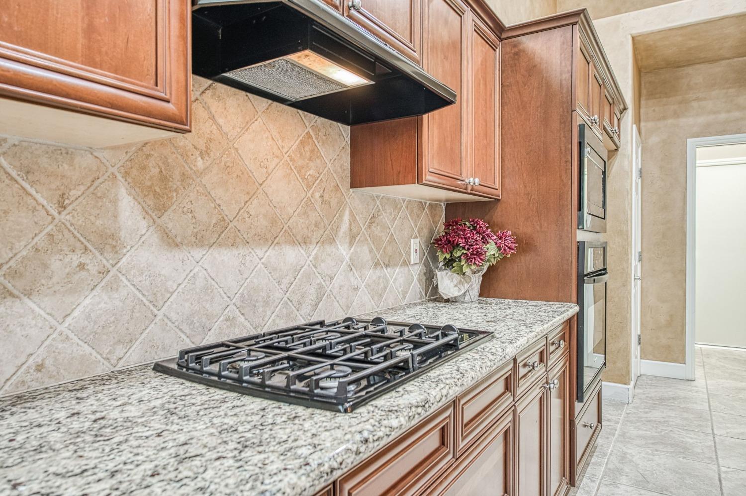 2267 Graybark Avenue Clovis, CA 93619 - Photo 24 of 42 a stove top oven sitting inside of a kitchen