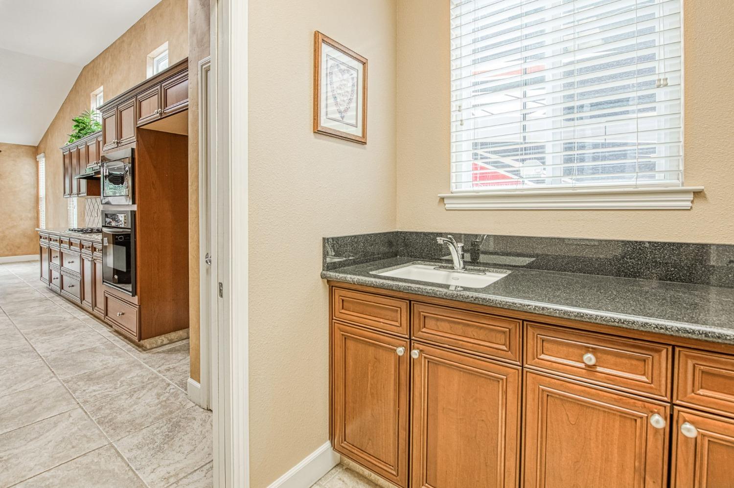 2267 Graybark Avenue Clovis, CA 93619 - Photo 26 of 42 a bathroom with a granite countertop sink and a window