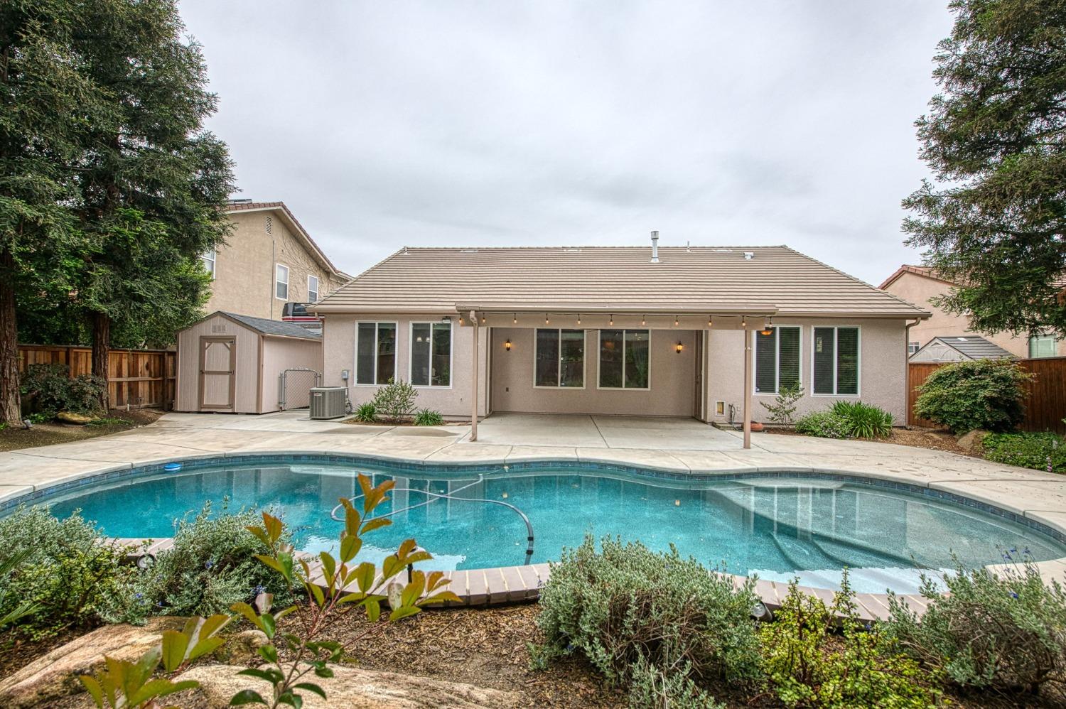 2267 Graybark Avenue Clovis, CA 93619 - Photo 39 of 42 a front view of a house with swimming pool having outdoor seating