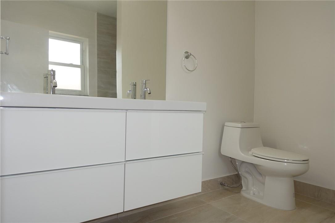 1311 Southwest 12th Avenue Boca Raton, FL 33486 - Photo 17 of 66 a bathroom with a toilet sink and mirror