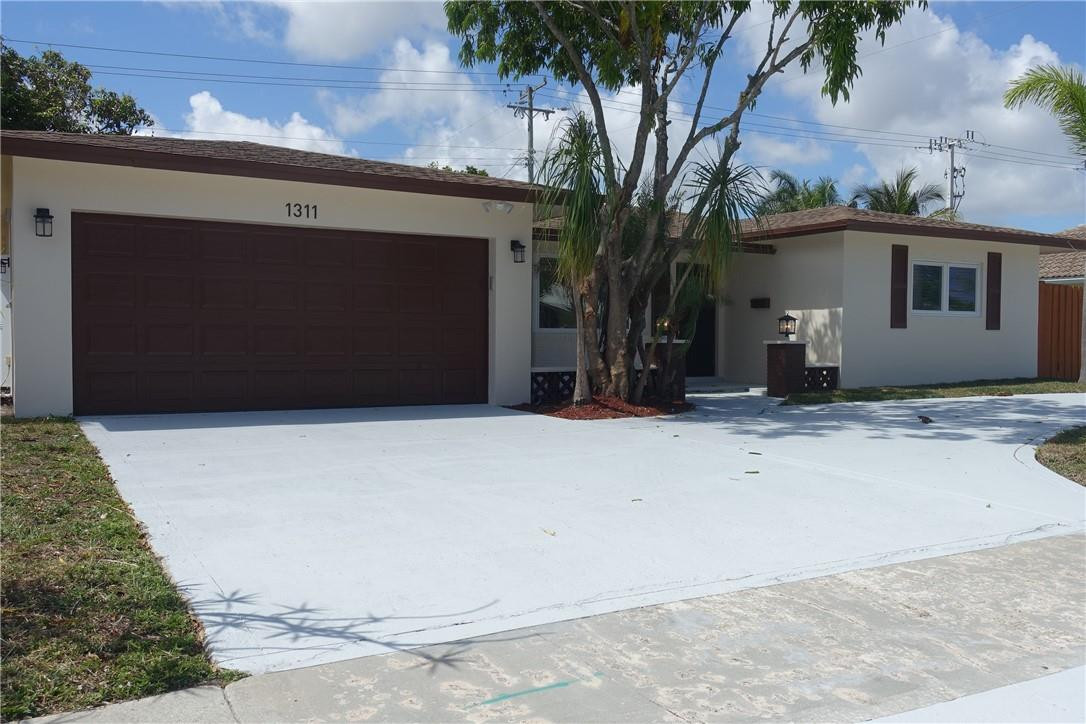 1311 Southwest 12th Avenue Boca Raton, FL 33486 - Photo 2 of 66 a house with trees in front of it