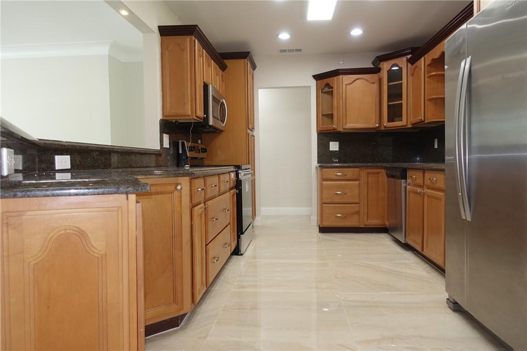 1311 Southwest 12th Avenue Boca Raton, FL 33486 - Photo 4 of 66 a kitchen with stainless steel appliances granite countertop a stove a sink and a refrigerator