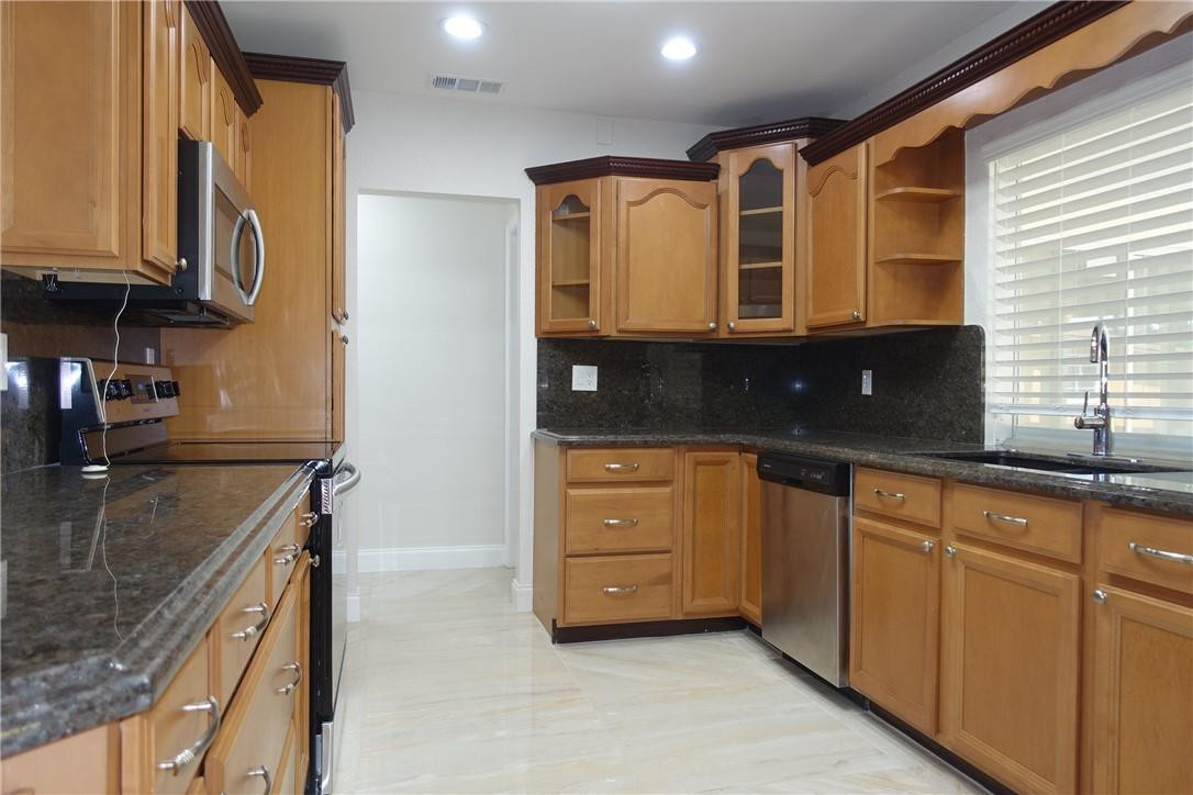 1311 Southwest 12th Avenue Boca Raton, FL 33486 - Photo 5 of 66 a kitchen with stainless steel appliances granite countertop a sink and a stove