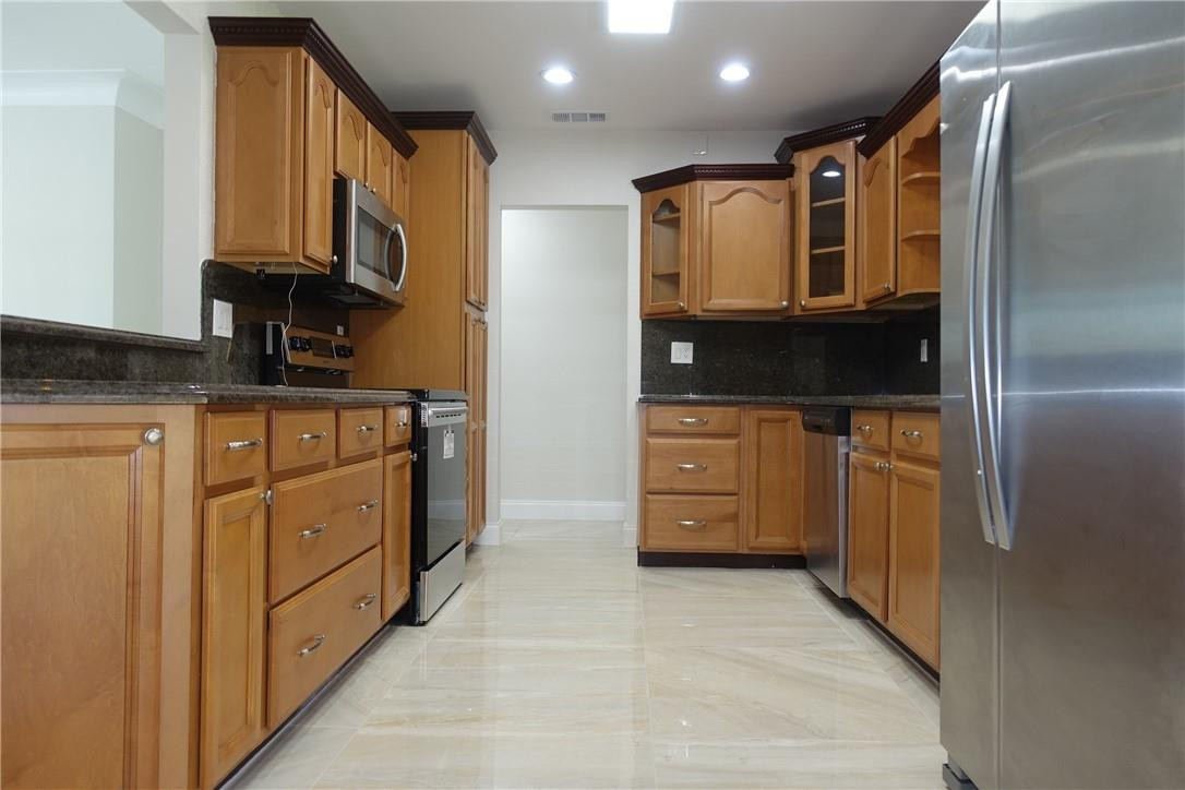 1311 Southwest 12th Avenue Boca Raton, FL 33486 - Photo 6 of 66 a kitchen with stainless steel appliances granite countertop a refrigerator and a stove