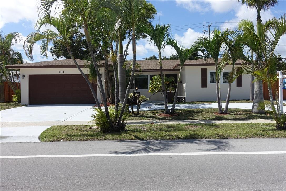 1311 Southwest 12th Avenue Boca Raton, FL 33486 - Photo 63 of 66 a front view of a house with garden