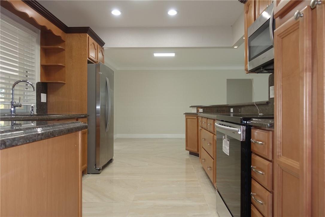 1311 Southwest 12th Avenue Boca Raton, FL 33486 - Photo 7 of 66 a kitchen with stainless steel appliances granite countertop a sink and a stove