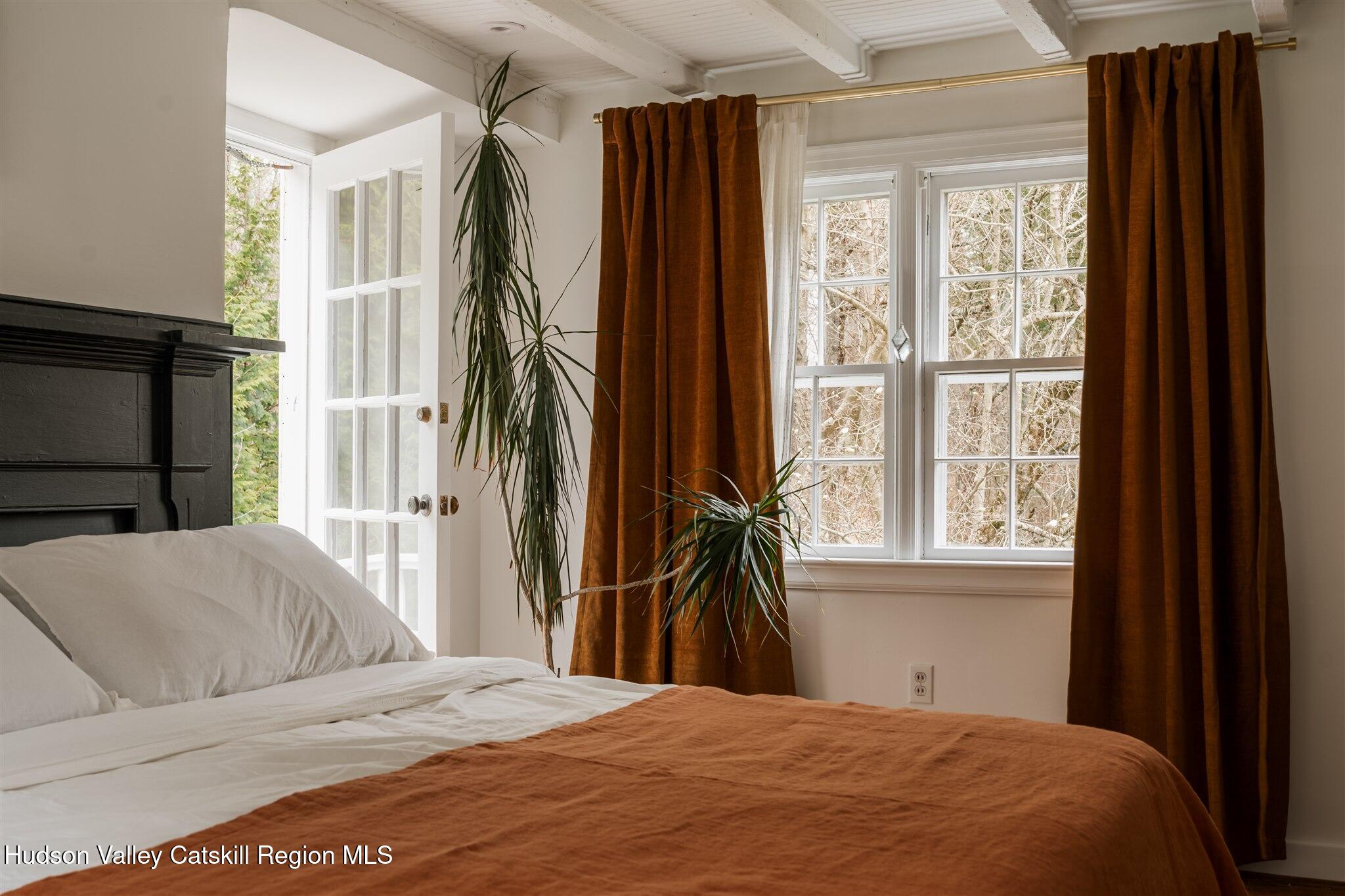 15 Dashville Road New Paltz, NY 12561 - Photo 29 of 38 a bedroom with a bed and a flat tv screen next to a window