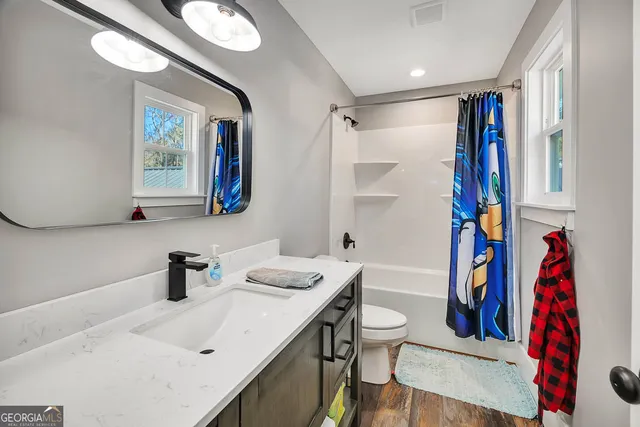 a large kitchen with granite countertop a lot of counter space and a view of living room