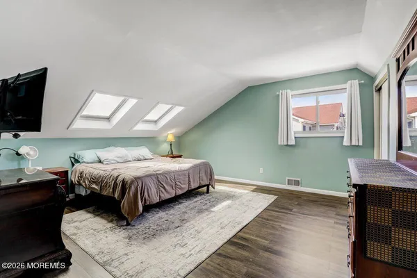 a spacious bedroom with a bed and a flat screen tv