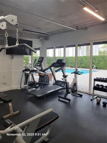 a room with gym equipment and large windows