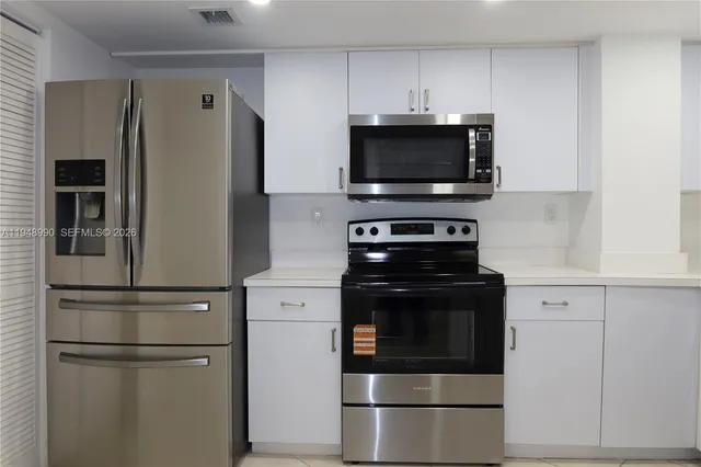 a kitchen with a refrigerator stove and microwave