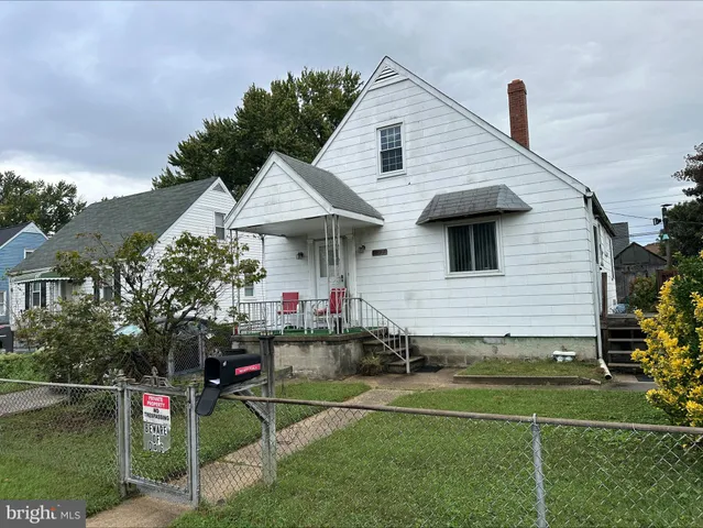 a front view of a house with a yard and potted plants