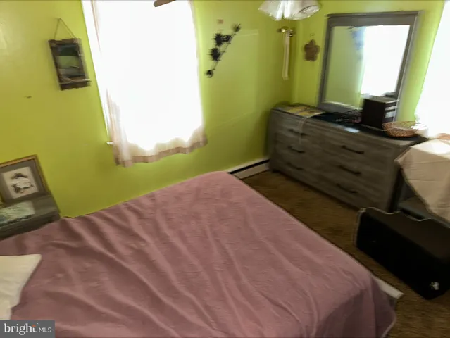 a bedroom with a bed window and dresser