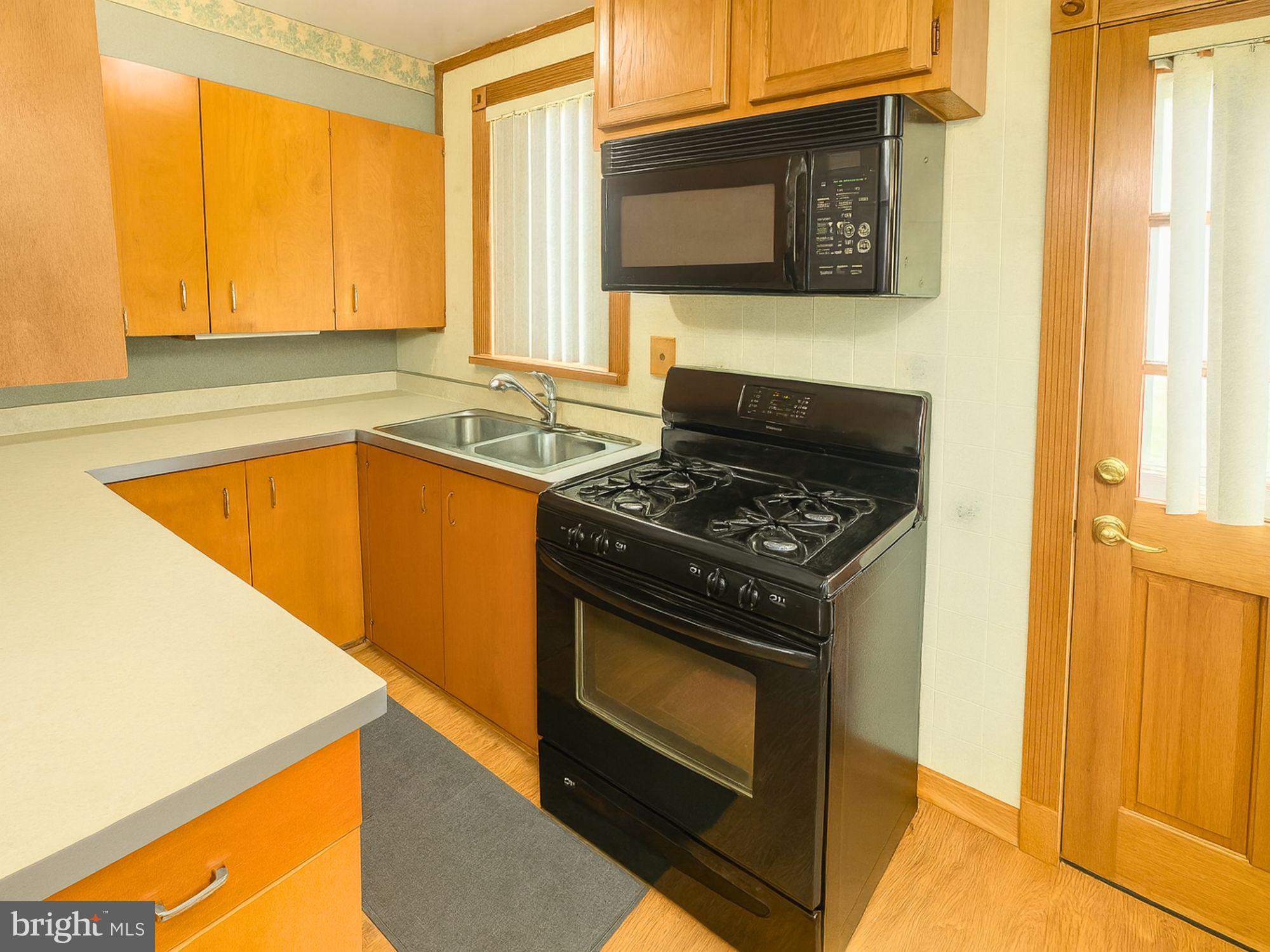 1747 Brookview Road Baltimore, MD 21222 - Photo 4 of 13 a kitchen with a stove and a microwave