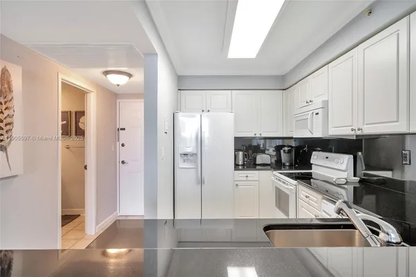 a kitchen with stainless steel appliances a refrigerator a sink a stove and cabinets
