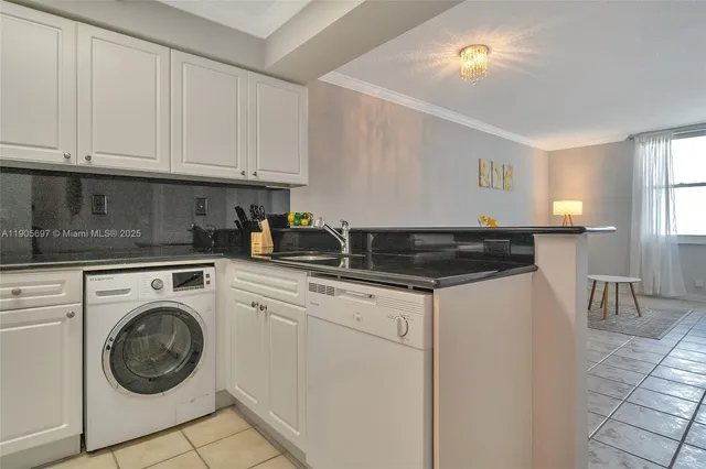 a kitchen with granite countertop white cabinets and a sink