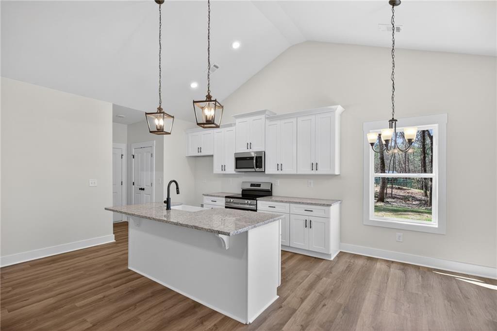 57 Oak Grove Road Taylorsville, GA 30178 - Photo 17 of 42 a kitchen with kitchen island white cabinets and black stainless steel appliances