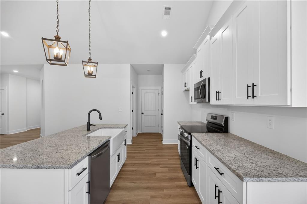 57 Oak Grove Road Taylorsville, GA 30178 - Photo 19 of 42 a kitchen with stainless steel appliances granite countertop a sink stove and cabinets