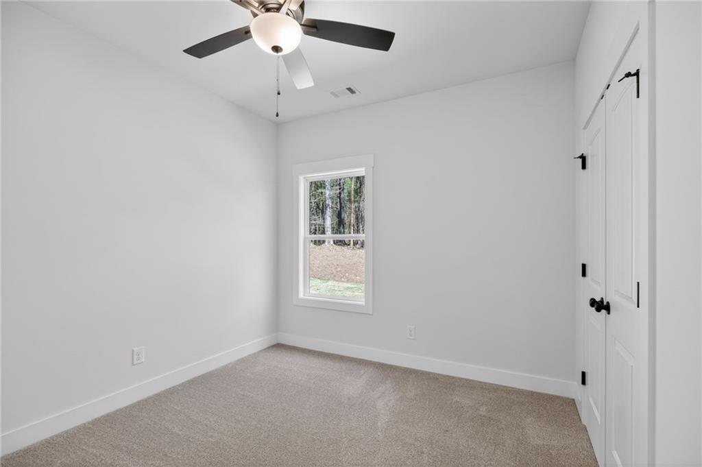 57 Oak Grove Road Taylorsville, GA 30178 - Photo 32 of 42 an empty room with a window and a fan