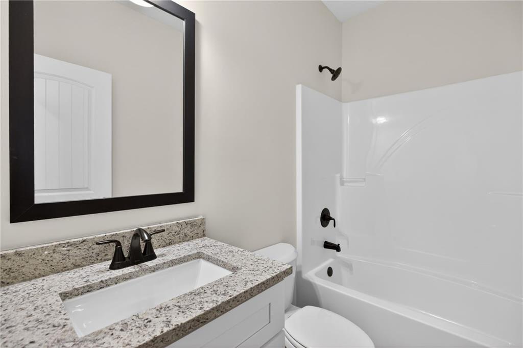 57 Oak Grove Road Taylorsville, GA 30178 - Photo 33 of 42 a bathroom with a granite countertop bathtub sink vanity mirror and toilet