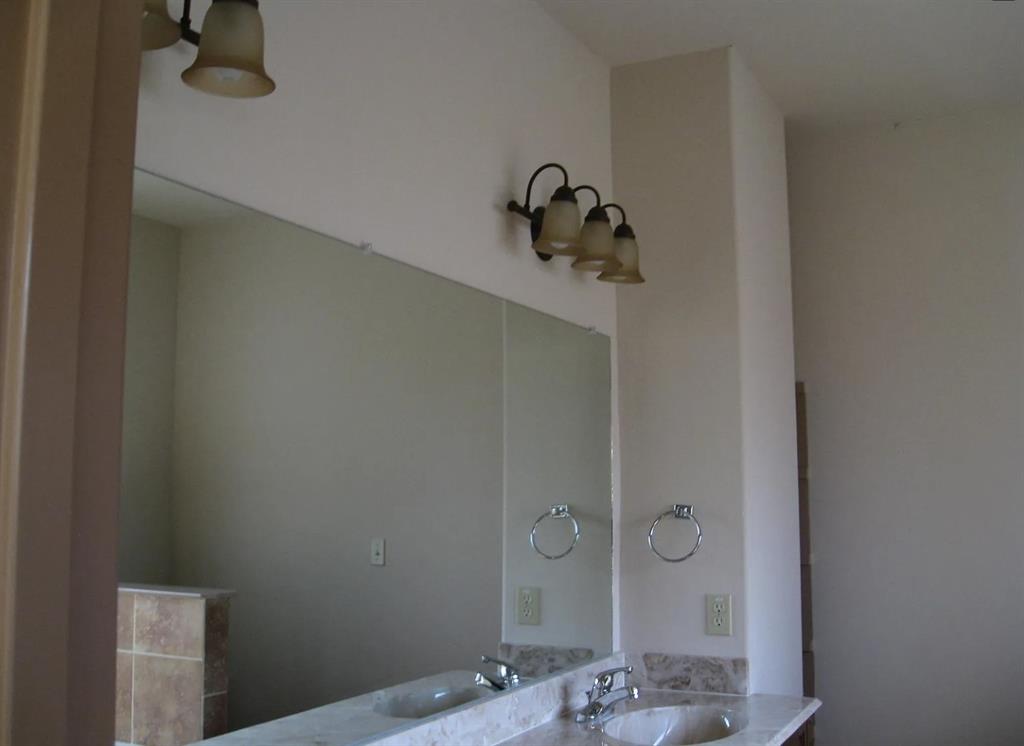Dual vanity with integrated sinks, polished chrome faucets, and stone countertop