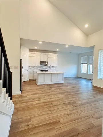 a view of a hallway with wooden floor and entryway