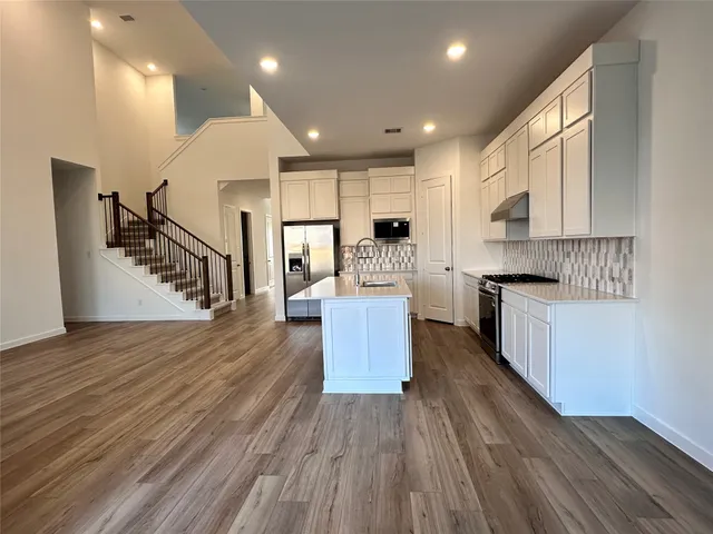 a kitchen with counter top space and wooden floor